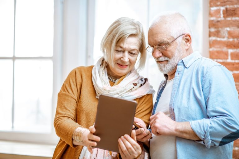 Senior couple with digital tablet at home