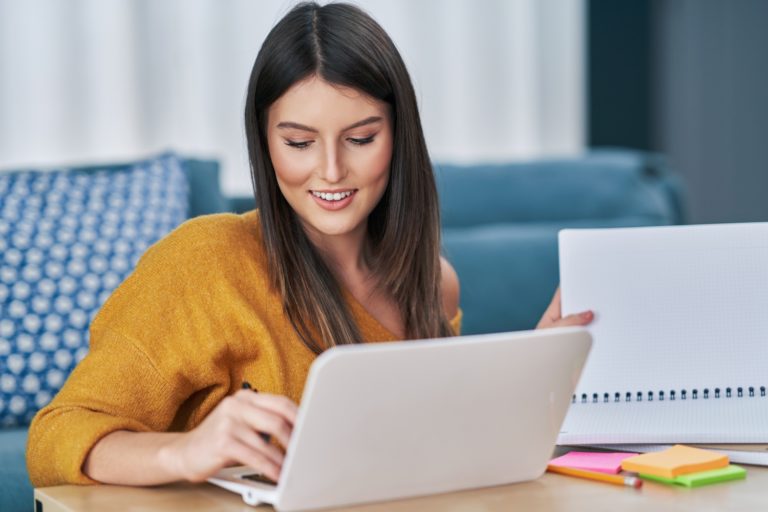 Picture of young woman using computer at home