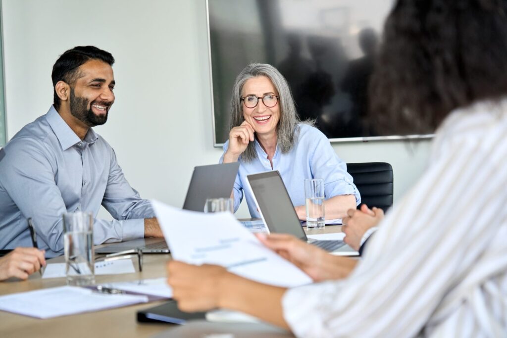 Happy diverse corporate team working together in meeting room office
