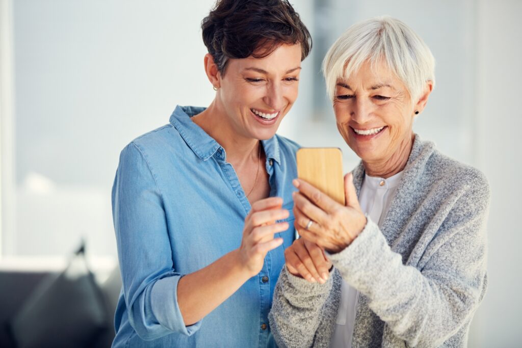 mother and daughter using mobile phone with home care software