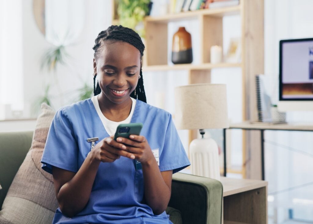 woman caregiver using mobile to check home care software at home