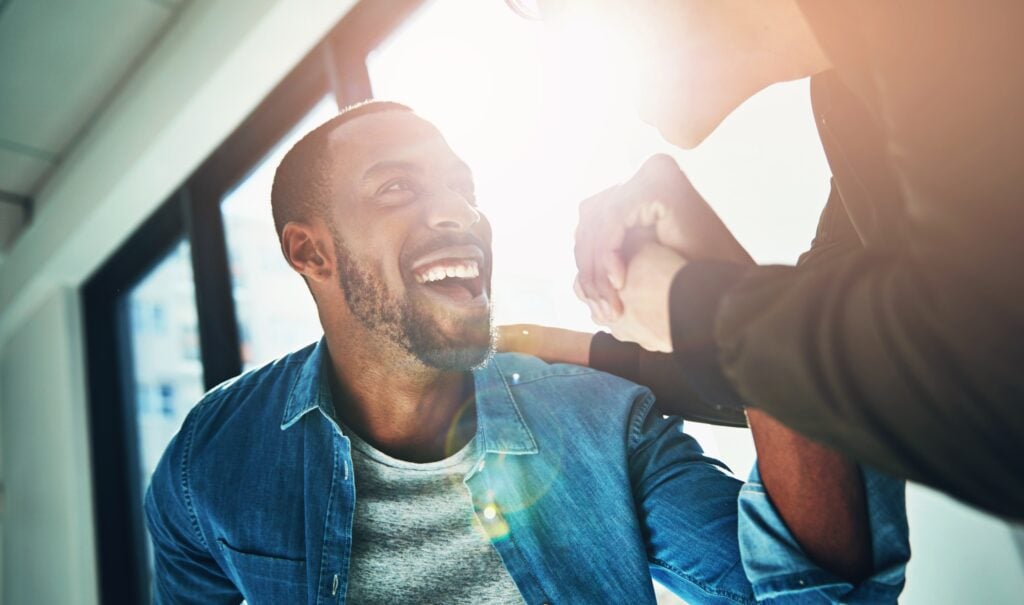 happy, smiling man doing a handshake, concept of recognition and job satisfaction