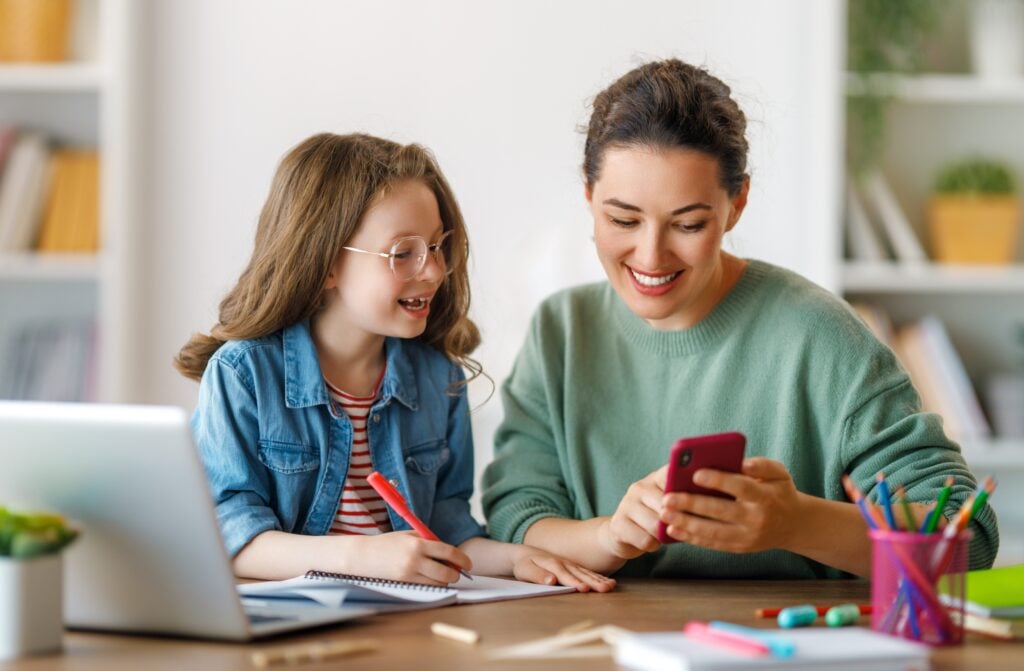 young girl doing homework with nanny, concept of childcare