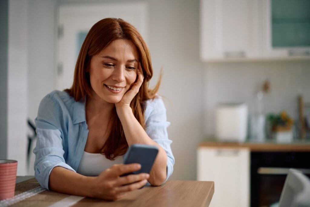 woman using mobile phone to book online, concept of childcare and babysitting