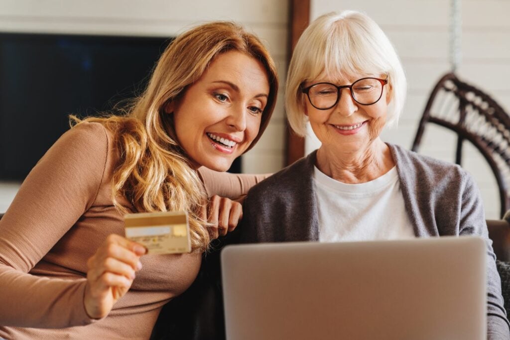 Senior woman and her middle aged daughter processing an online payment
