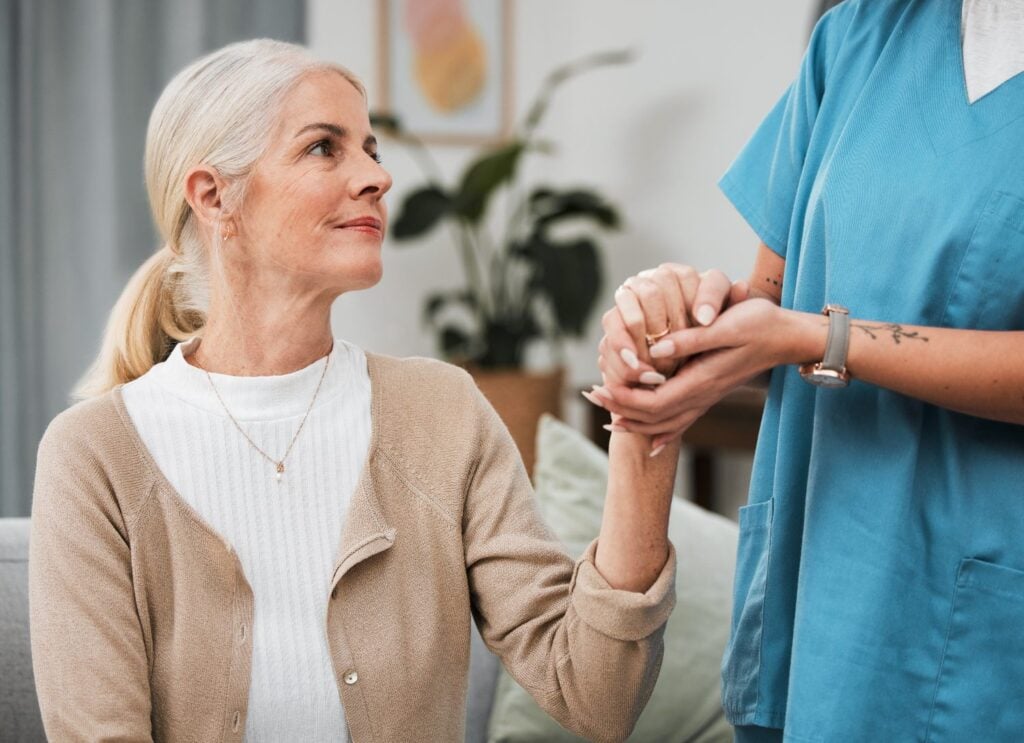 senior woman holding hands with caregiver, concept of trust and reliability