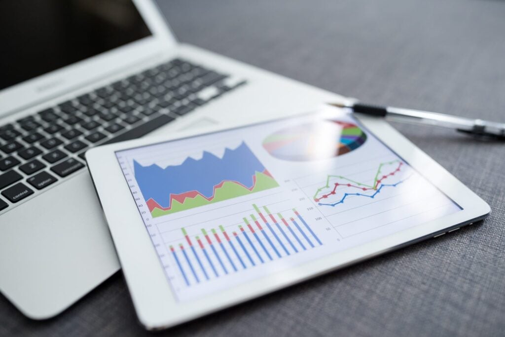 close up shot of a laptop and tablet device showing data, graphs and information management