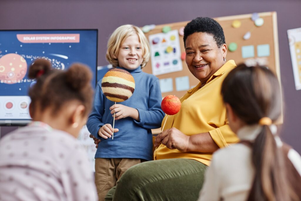 smiling childcare nanny spending time and teaching kids