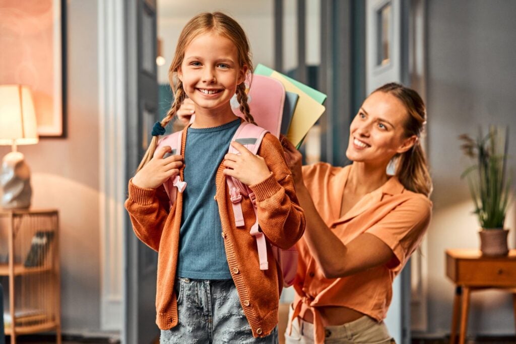 young girl wearing her backpack for school, childcare nanny assistance, concept of childcare