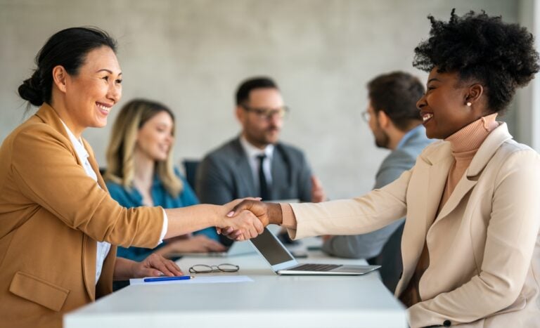 two women shaking hands after a job interview, concept of hiring and recuitment
