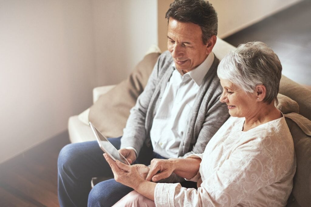 senior couple looking at a tablet device