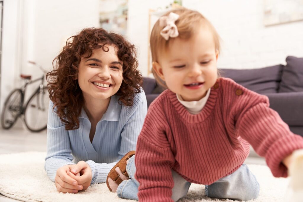 smiling nanny while playing with a toddler, concept of childcare