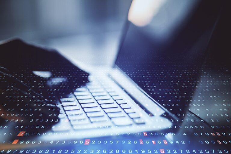 close up shot of hands typing on a computer laptop, concept of payroll management
