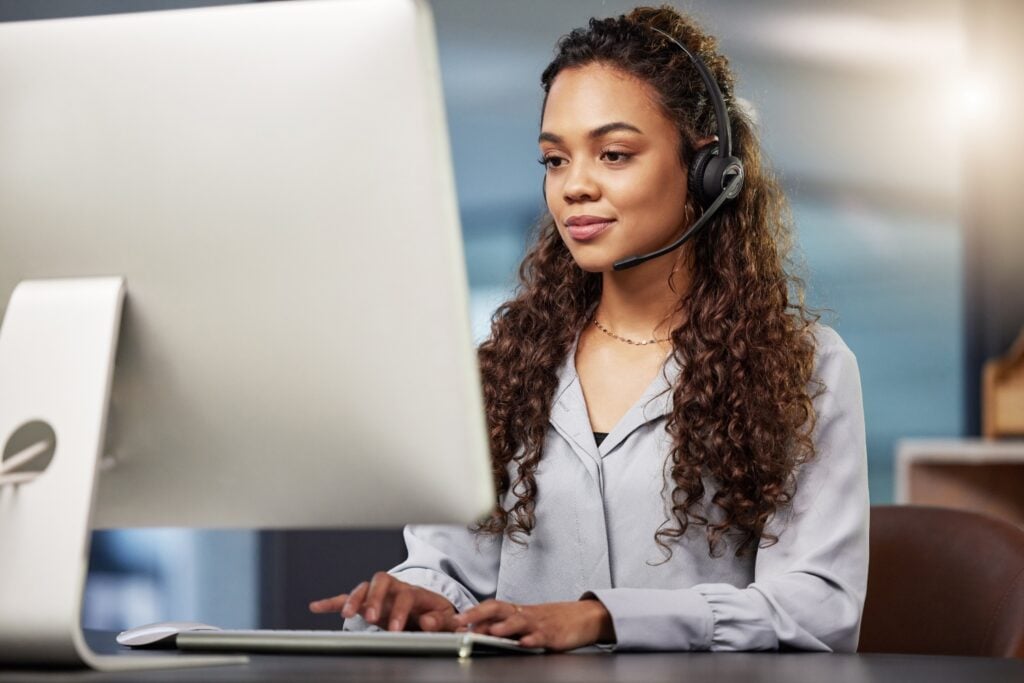 female employee using desktop computer while talking on the phone