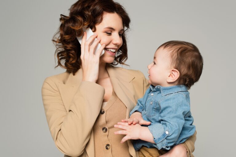 happy mother using phone calling home care while holding a baby, concept of childcare
