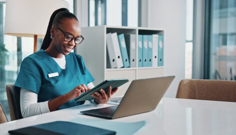 nurse caregiver using computer and tablet in an office, concept of homecare software