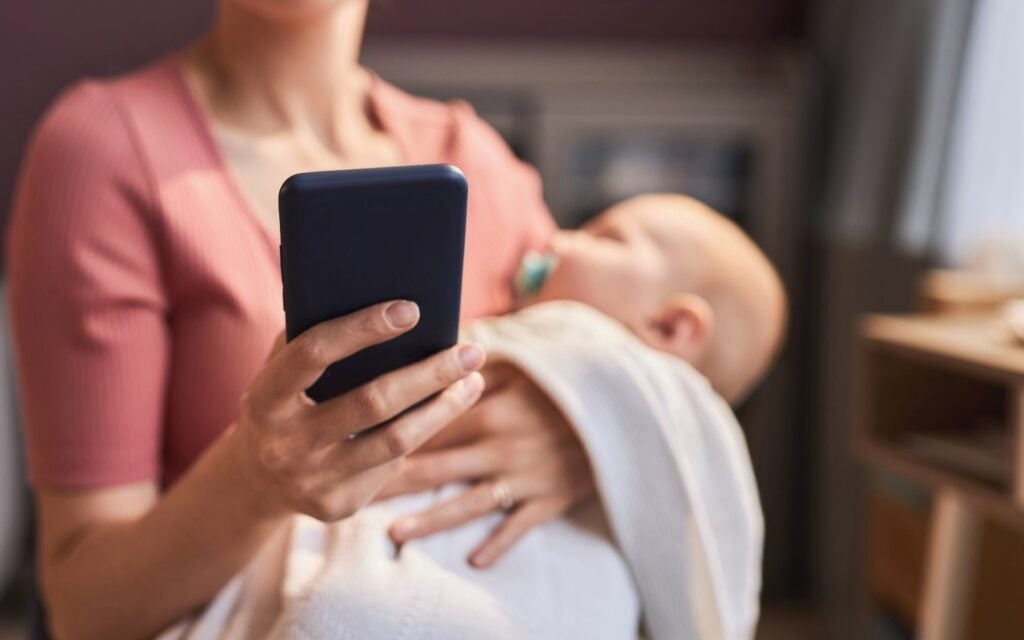 Holds Baby While Using Mobile Phone