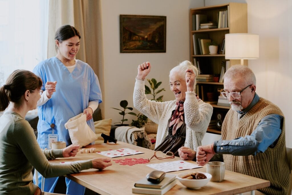 caregivers playing interacting with seniors in a senior home