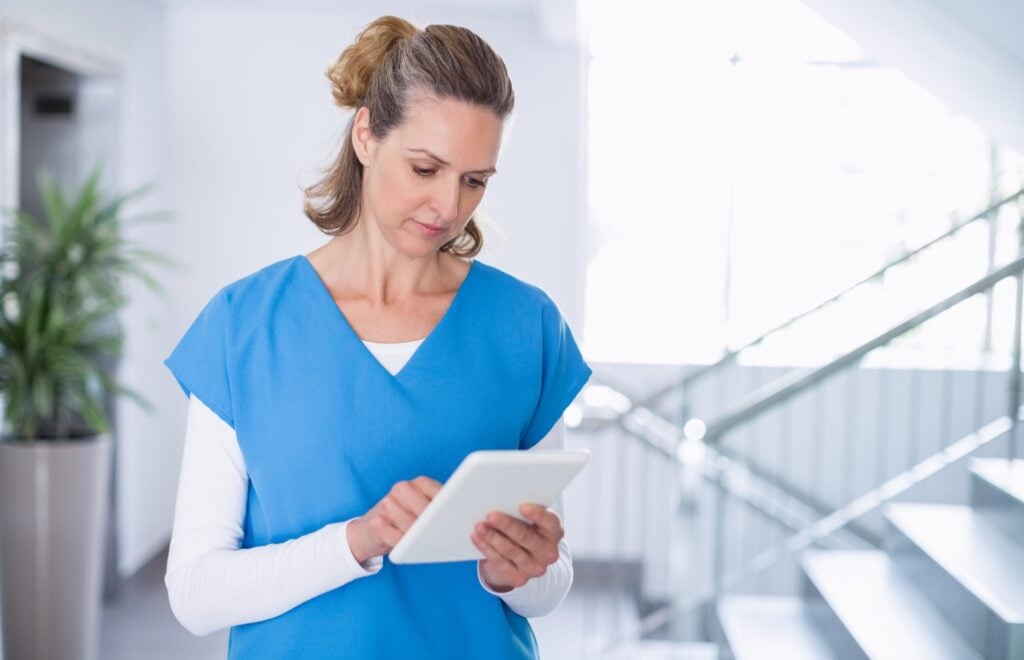female caregiver using tablet during a visit, concept of electronic visit verification
