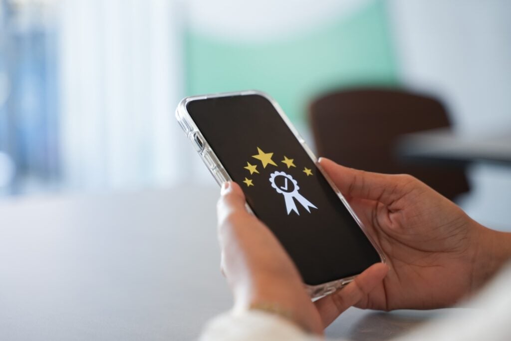 hand is holding a mobile phone displaying a rating application