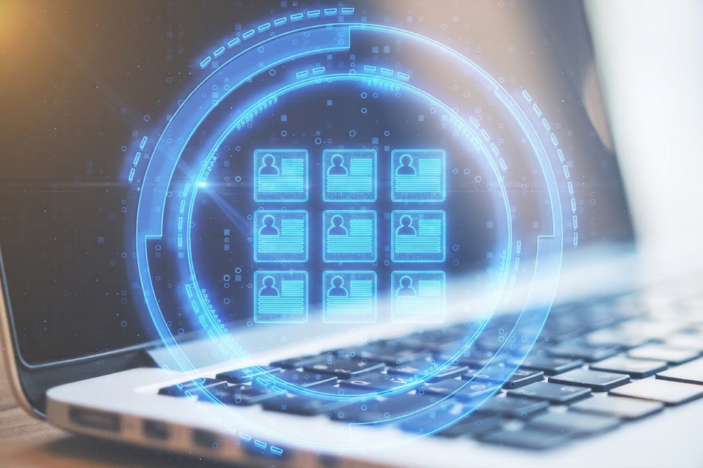 laptop displaying a digital profile icon surrounded by technological data